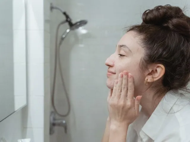 鏡の前で洗顔をする女性