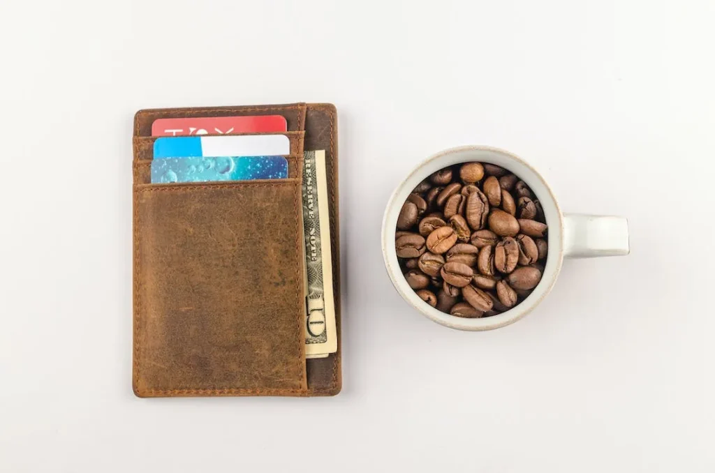 茶色の財布とカップに入ったコーヒー豆
